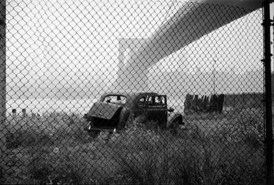 USA. New York City. 1955. Abandoned car next to Brooklyn Bridge.